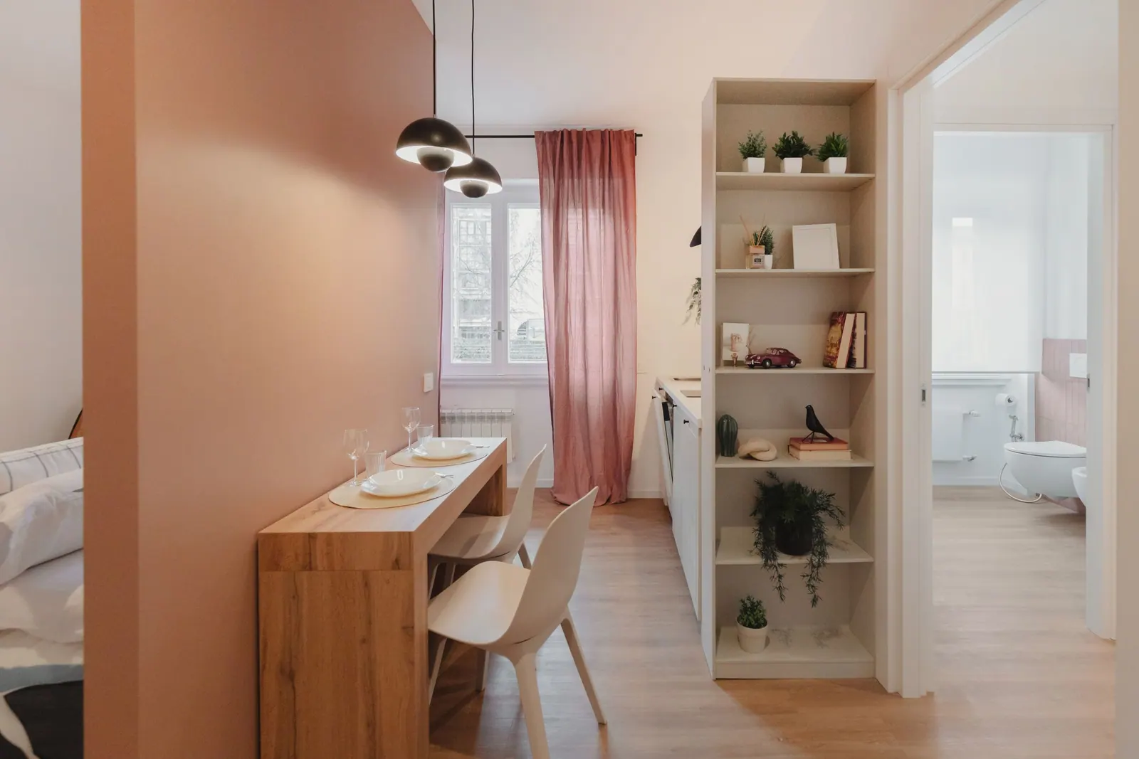 Mono Terracotta: Wohnbereich mit Terrakotta-Wand, Tisch und Bücherregal